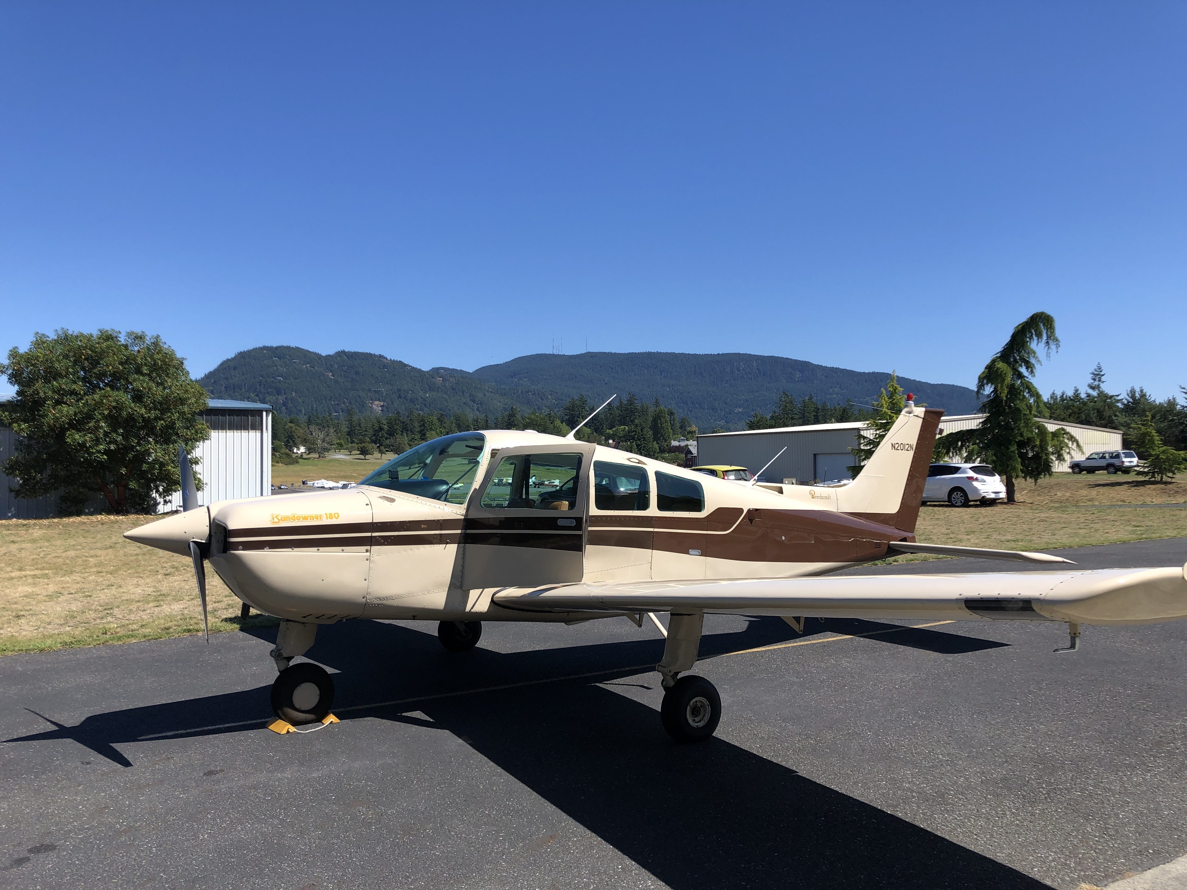 N2012N Bugs, a brown-striped Beechcraft Sundowner on the ramp at Orcas Island